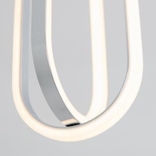 Close-up of the Arlo 1-light LED pendant by Artika, featuring curved, glowing white LED strips and a reflective metal surface against a plain light gray background.