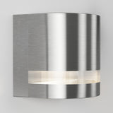 A modern, wall-mounted brushed metal sconce with a curved design and a horizontal frosted strip emitting soft white light.