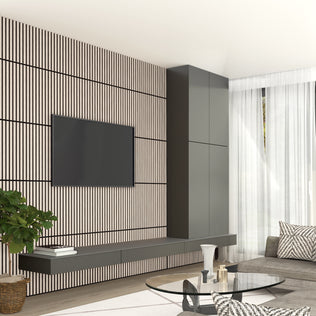 Modern living room featuring an Artika Sonolok 15.5 ft sound-absorbing wall panel kit (4-pack) as a striped accent wall, with a wall-mounted TV, floating shelves, gray sofa, round glass coffee table, tall cabinets, and sheer white curtains.