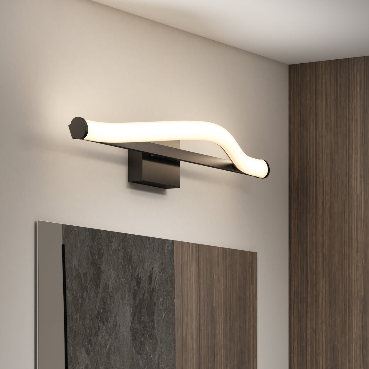 A modern wall-mounted light fixture with a wavy, glowing LED design is installed above a mirror on a light-colored wall, next to a section of wood paneling.