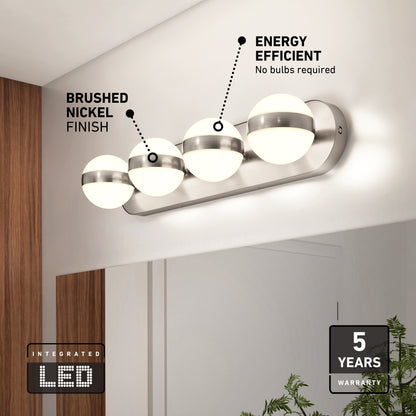 A modern brushed nickel light fixture with three globe LED lights is mounted above a bathroom mirror. Text highlights its energy efficiency and 5-year warranty. Some green plants are visible at the bottom right.