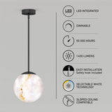 A round pendant LED light with a marbled white shade hangs from the ceiling. Icons and text highlight features: LED integrated, dimmable, 50,000 hours, 1400 lumens, easy installation, selectable white, and sloped ceiling compatible.