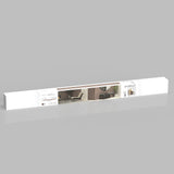 A long, rectangular white package with a central image showing a modern living room featuring a wooden accent wall, a chair, a small table, and a round mirror. The package has labels and branding on the left side.