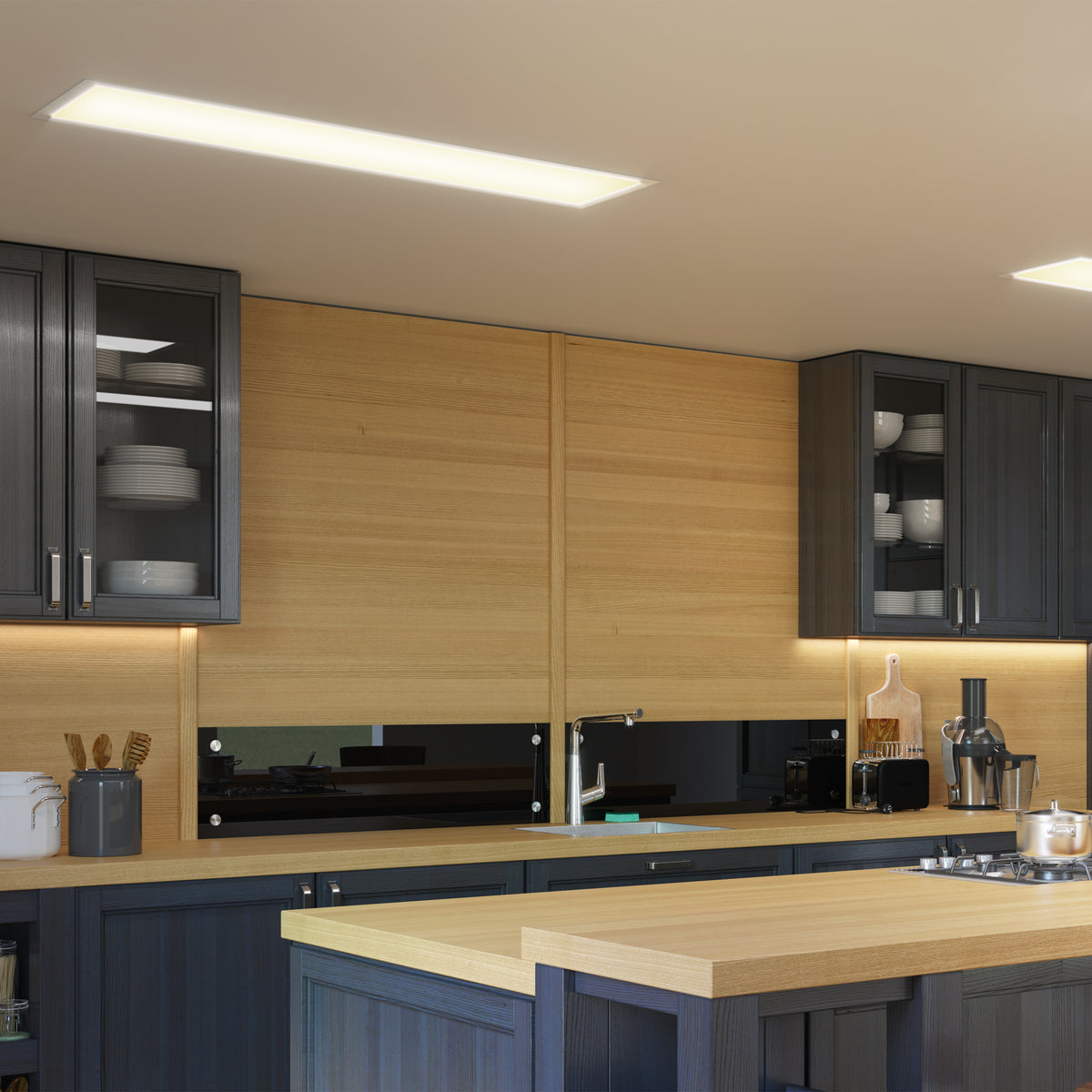 Modern kitchen with dark cabinets, light wood countertops and walls, glass cabinet doors displaying dishes, under-cabinet lighting, and various kitchen utensils and appliances on the counter and island.