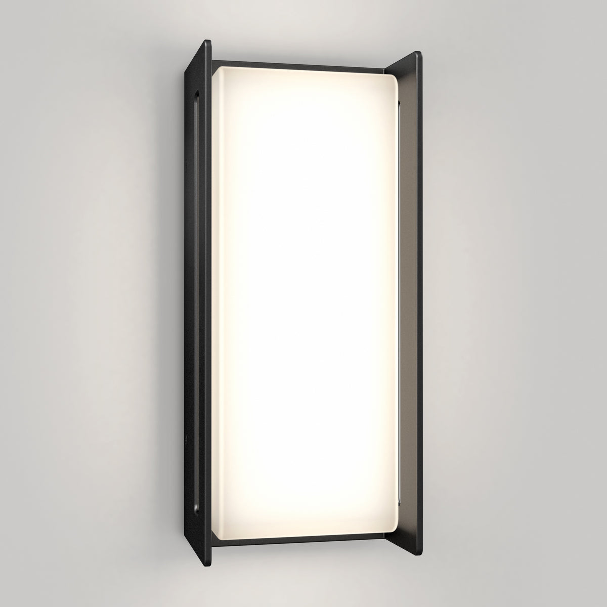The Artika Ryker smart RGB indoor-outdoor wall light features a rectangular frosted glass panel framed by two vertical black metal sides, emitting customizable light against a light gray wall.