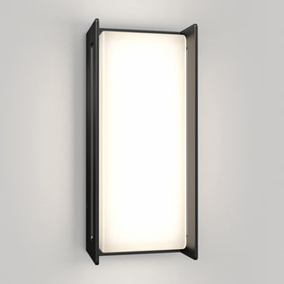 The Artika Ryker smart RGB indoor-outdoor wall light features a rectangular frosted glass panel framed by two vertical black metal sides, emitting customizable light against a light gray wall.