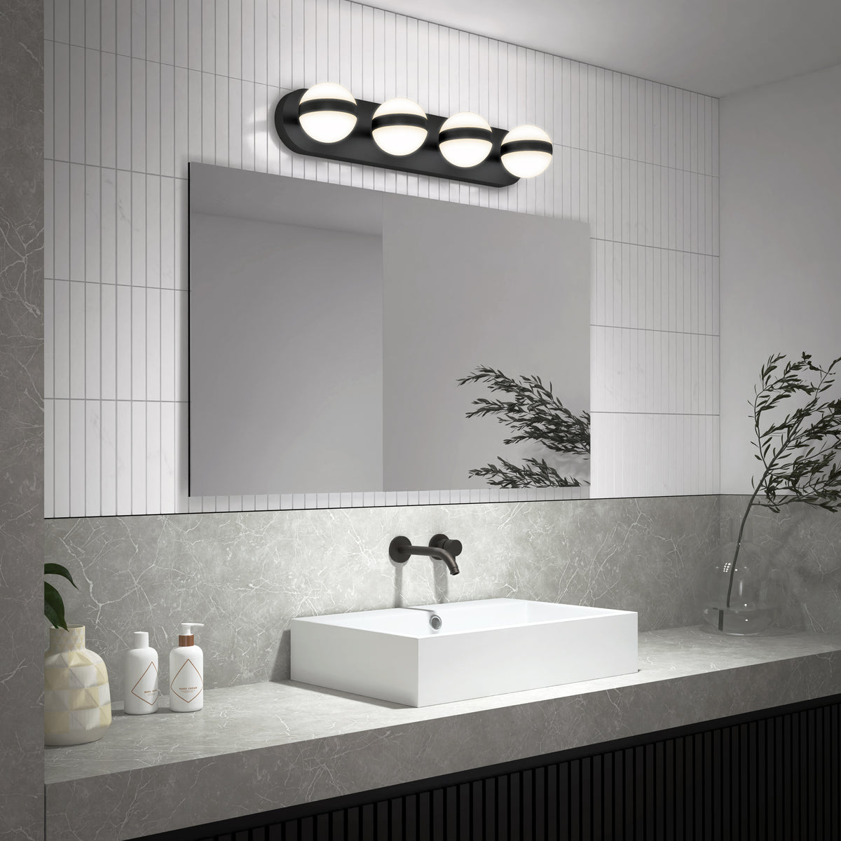 A modern bathroom with a rectangular mirror, wall-mounted black faucet, white square sink, and four globe lights above. Decorative items and greenery sit on a gray countertop with a tiled backsplash.