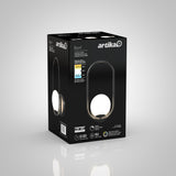 A black box packaging for the Artika Bloom LED table lamp featuring an image of the lamp, product details, an energy rating label, and icons highlighting features like 50,000-hour lifespan and energy efficiency.