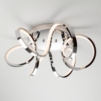 The Artika Swirl Ribbon LED flush mount light features intertwined chrome loops with integrated LED strips on a round base, offering stylish illumination and a modern touch to any contemporary space.
