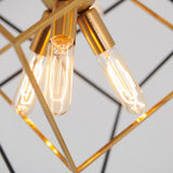 Close-up of three exposed filament light bulbs in gold sockets, arranged within a geometric metal frame. The bulbs are lit, creating a warm and modern aesthetic against a light background.
