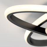 Close-up of a modern ceiling light fixture with curved, overlapping LED strips emitting soft white light against a neutral background. The fixture features sleek black and white elements.