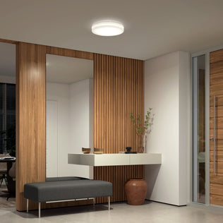 Modern entryway with wood panel walls, mirror, shelf, bench, vase, and Artika Hemisphere 15 in. Modern LED Ceiling Light 5 CCT.