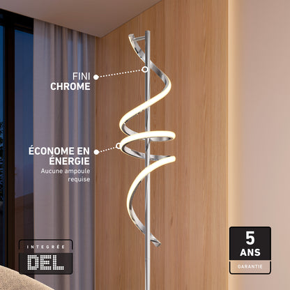 The Coda modern LED floor lamp 5CCT by Artika, featuring a sleek chrome finish and no bulb required, stands by a wooden wall. This dimmable, energy-efficient lamp comes with a 5-year warranty and softly illuminates the evening through the window.