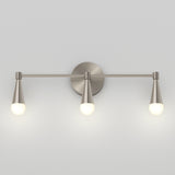 A modern wall-mounted light fixture with three cone-shaped bulbs attached to a horizontal metal bar on a round base, all in a brushed nickel finish, against a plain light gray wall.