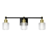 A modern three-light wall sconce with a black horizontal bar, gold accents, and three clear cylindrical glass shades mounted on a rectangular black base.