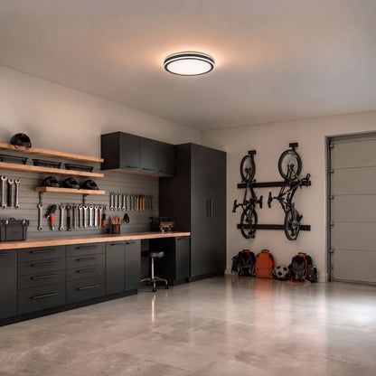 An Altitude 15 in. (38 cm) Modern LED Flush Mount Ceiling Light 5 CCT illuminates a garage workshop.