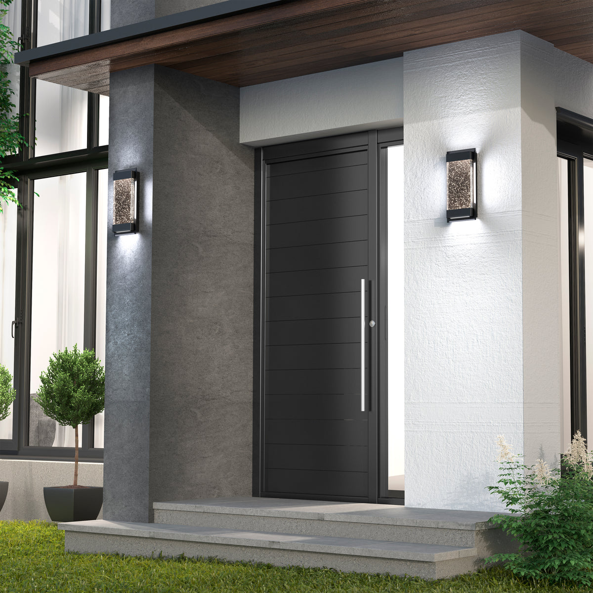 Modern front entrance with a sleek black door, horizontal panels, and a long vertical handle. Flanked by textured wall lights, potted shrubs, and surrounded by concrete and white walls. Steps lead up from a green lawn.