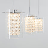 A row of modern pendant lights with clear glass shades and geometric crystal patterns, hanging from the ceiling against a light gray background.
