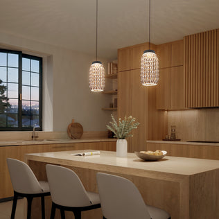 Modern kitchen with light wood cabinets, a marble island with three white chairs, and Artika Benson Mini LED pendant lights (5 CCT, adjustable color temperature). A vase of flowers and apples decorates the island under warm ambient lighting.