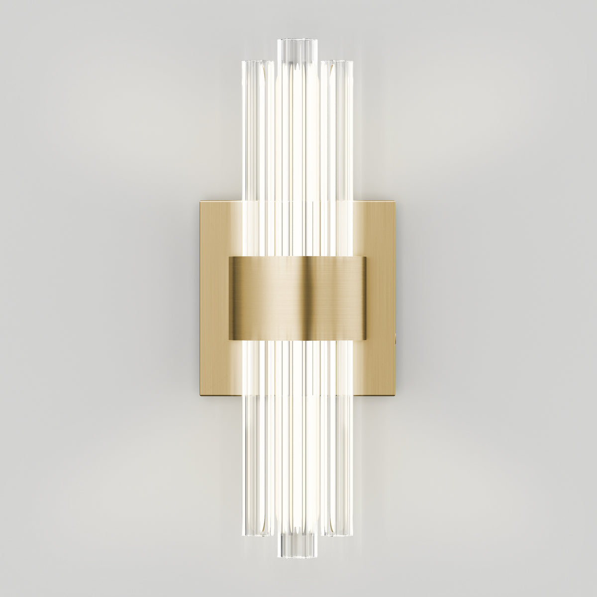 Artika’s Dorado contemporary LED wall sconce 3 CCT features a brushed gold base and vertical clear glass rods, casting a soft glow on light gray walls—an elegant luxury fixture for modern spaces.