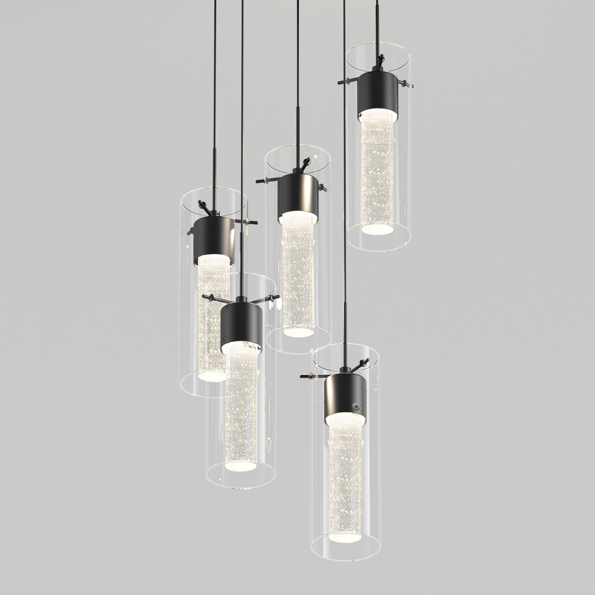 Six modern cylindrical pendant lights with clear outer glass and illuminated inner tubes hang at varying heights against a plain light gray background.