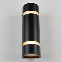 The Artika D4 indoor-outdoor wall light is a modern black cylindrical sconce that emits light from both the top and bottom, shown mounted on a light gray wall.
