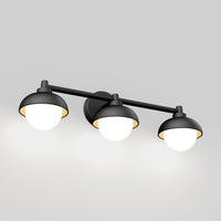 The Artika Boden 27-in (69 cm) Integrated LED 5-CCT Vanity Light Bar features three black and white round lampshades on a horizontal rod, each offering adjustable color temperature for a warm glow—ideal for modern bathrooms.
