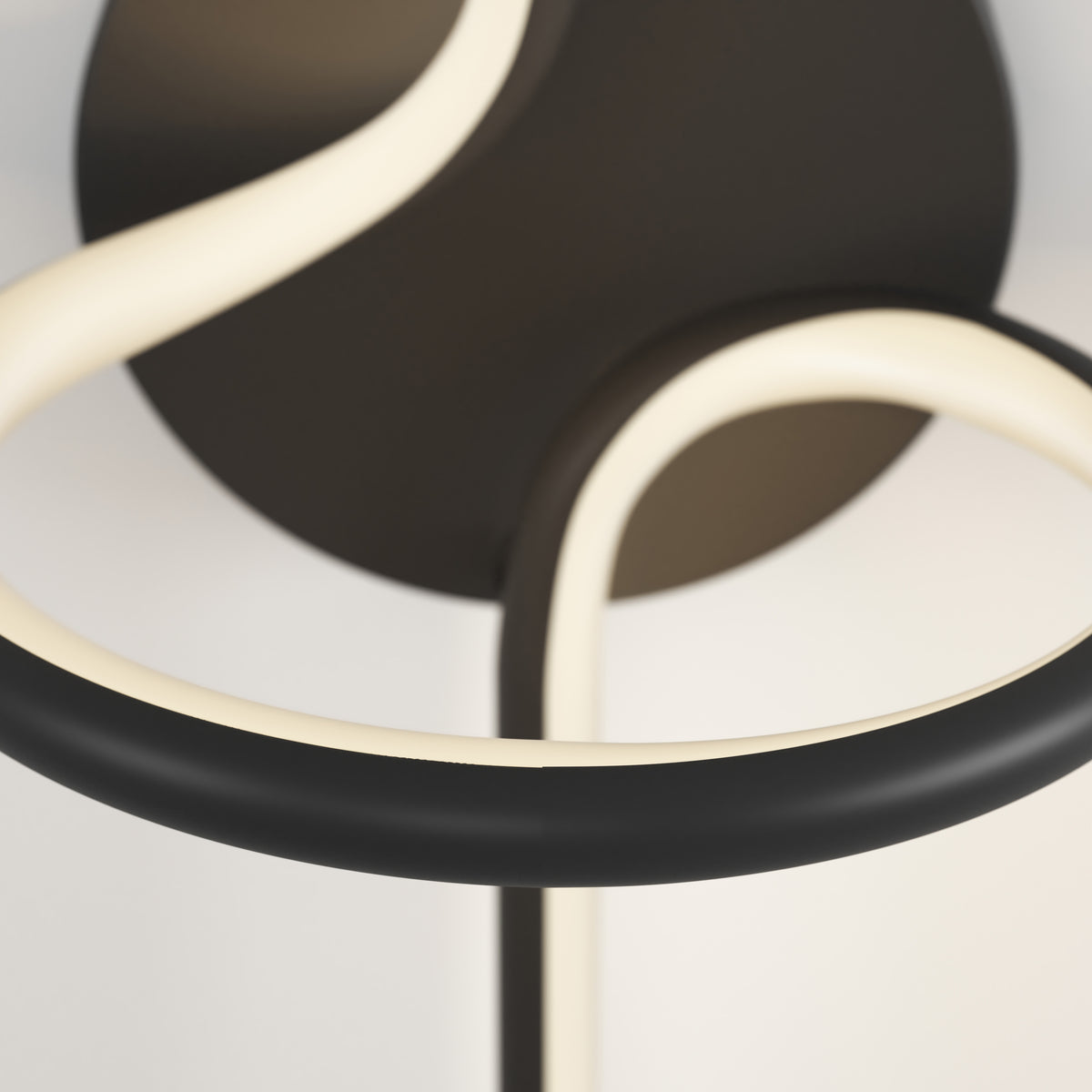 Close-up of the Swirl LED Sconce by Artika, showcasing its curved black and white LED tubes against a neutral background for an abstract, minimalistic effect.