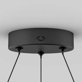 Close-up of the Artika Bjorn modern LED pendant light 5 CCTs round matte black ceiling mount with three black cords, shown against a plain light gray background.