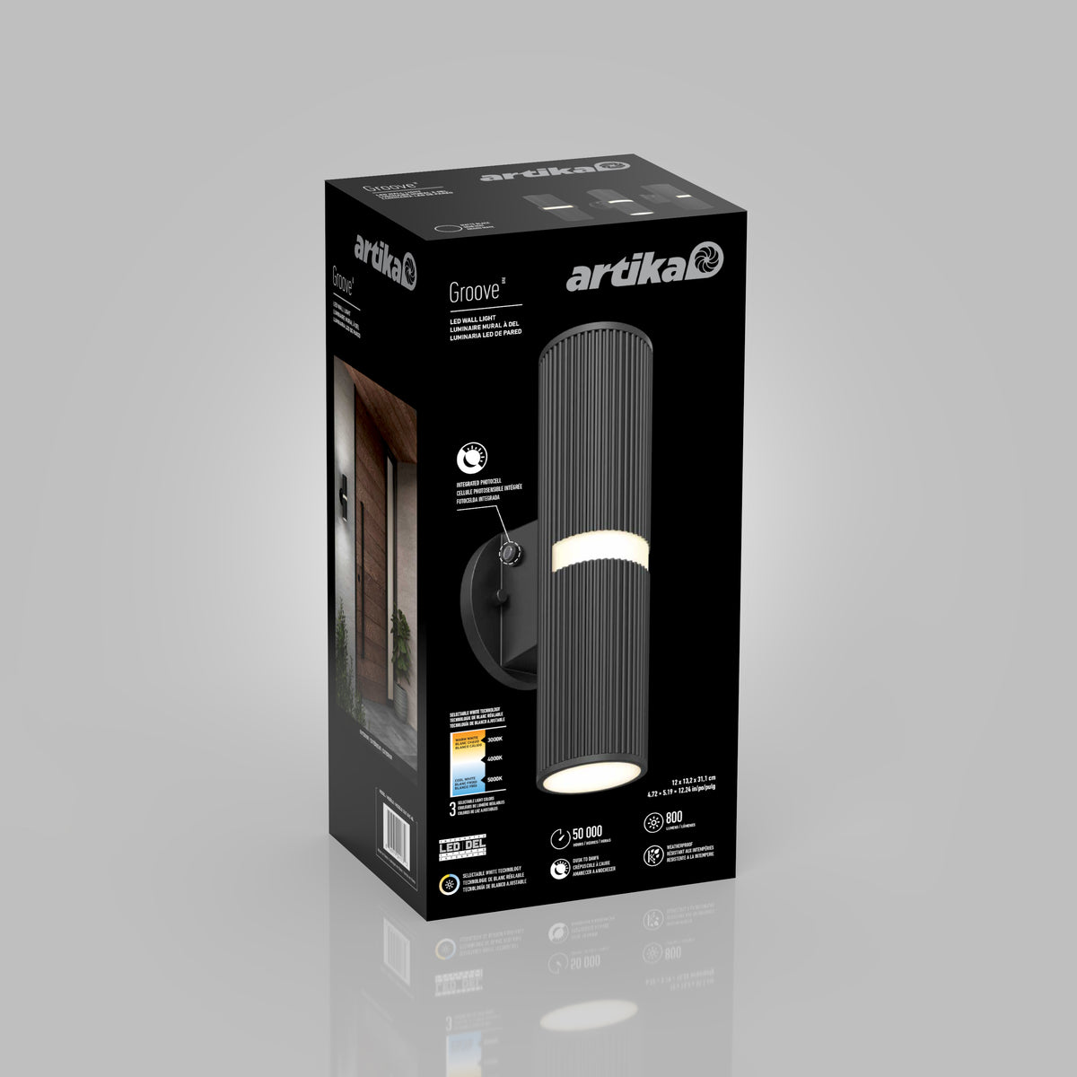 A black rectangular Artika box displays the Groove LED indoor-outdoor wall light. The package shows the cylindrical black fixture, specs, energy ratings, and an image of the light installed by a doorway.