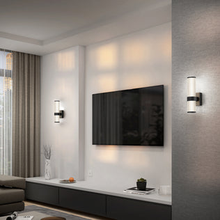 Modern living room with a wall-mounted TV, gray sofa, floor-length curtains, low black and white console with decor, and two Artika Mirado modern LED wall sconces (5 CCT) on either side of the TV.