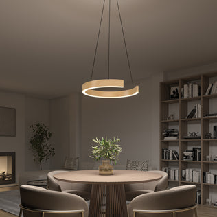 A modern dining room with a circular wooden table, four upholstered chairs, a potted plant centerpiece, built-in bookshelves in the background, and an Artika Vance modern LED pendant light 3 CCT hanging above.