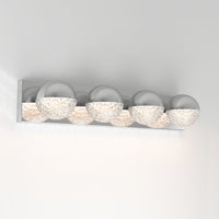 The Artika Carat 27-in (69 cm) Integrated LED Vanity Light Bar features four chrome and textured translucent spheres, casting soft, warm light against a white wall—a modern choice for bathroom lighting.