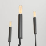 Three modern, cylindrical black pendant lights with exposed filament bulbs are suspended against a plain white background. The image is taken from a low angle, showing the lights at varying heights.