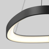 A close-up of a modern, black, oval-shaped pendant light with a glowing white interior, suspended by two thin wires against a plain grey background.