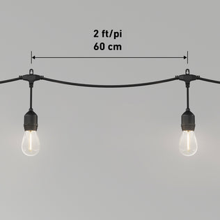 Two Artika Blaze 20 LED Outdoor Solar String Lights, spaced 2 feet (60 cm) apart on a black wire, are shown against a plain gray background with measurement text and arrows indicating the distance between bulbs.