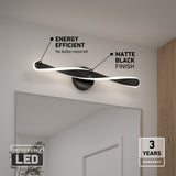 A modern matte black LED wall light is mounted above a mirror. Text highlights its energy efficiency, no bulbs required, matte black finish, and a 3-year warranty. An Integrated LED label appears in the lower left corner.