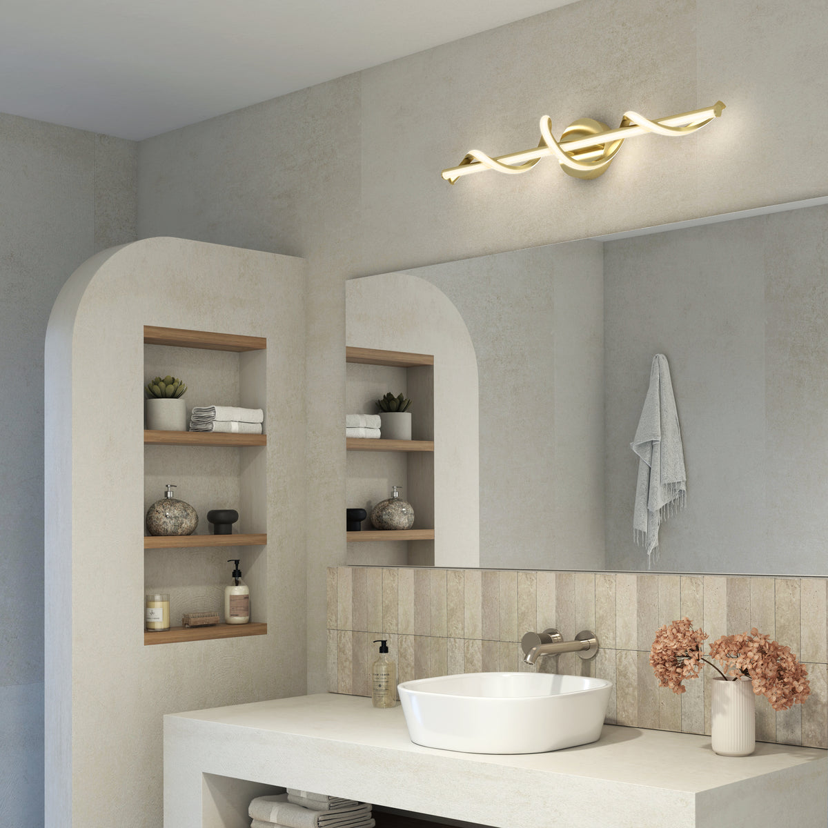 A modern bathroom with beige walls, a large mirror, vessel sink, open shelves with decor items, and a stylish gold twisted light fixture above the mirror. Dried flowers sit on the counter.