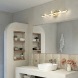 A modern bathroom with beige walls, a large mirror, vessel sink, open shelves with decor items, and a stylish gold twisted light fixture above the mirror. Dried flowers sit on the counter.