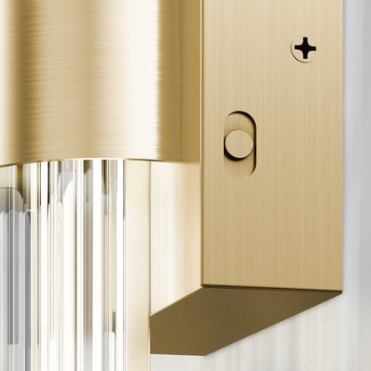 Close-up of the Artika Dorado LED contemporary wall sconce 3 CCT, showcasing a brushed gold finish, clear glass rods, and detailed screw and button accents on its modern metal surface.