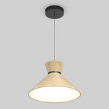 A modern ceiling pendant light with a wooden, hourglass-shaped shade and a black ceiling mount, suspended by a thin black cord, emits a soft, warm glow against a plain gray background.