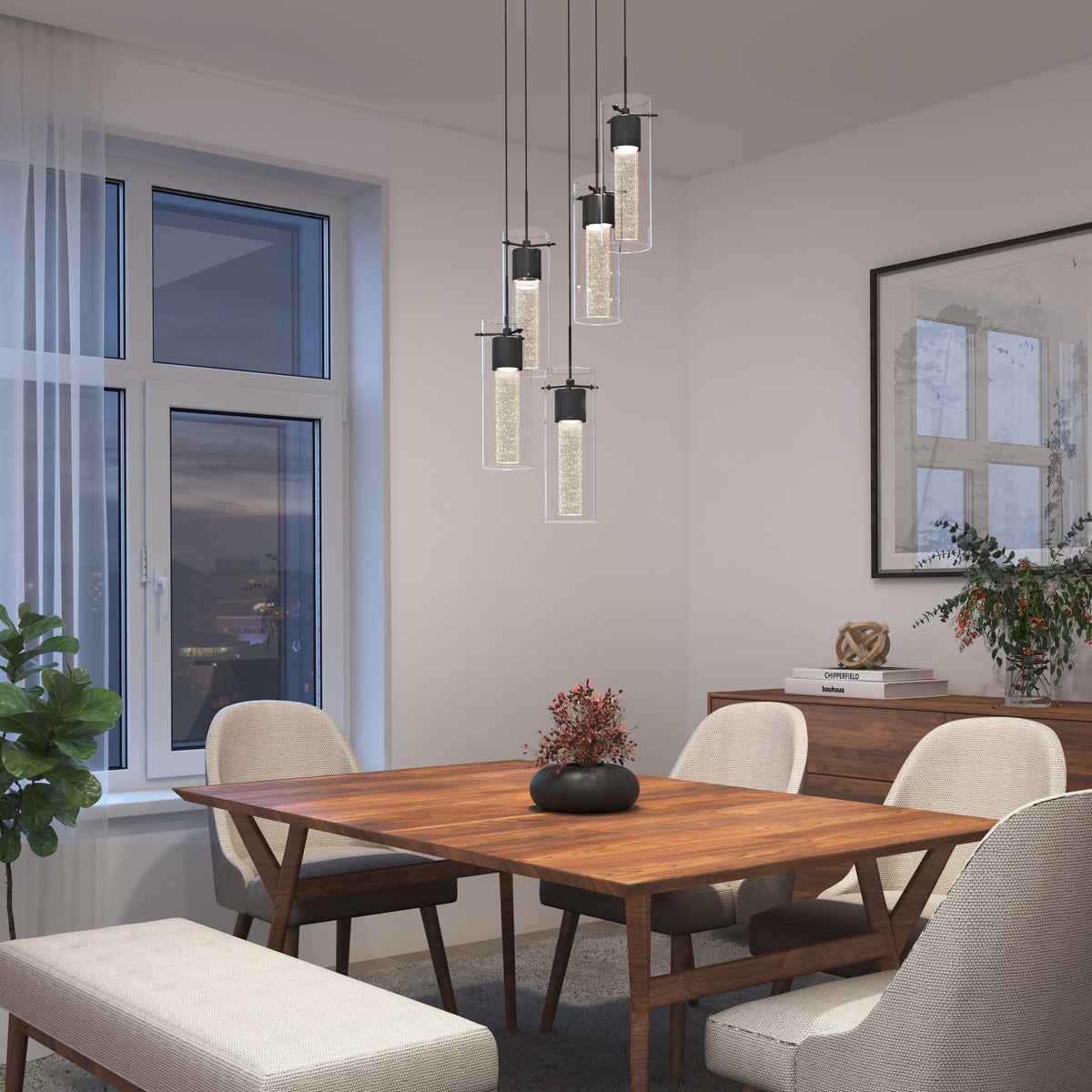 A modern dining room with a wooden table, four upholstered chairs, a bench, a potted plant, pendant lights, and a sideboard with décor, set against white walls and a large window with sheer curtains.