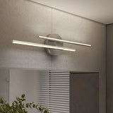 A modern wall-mounted light fixture with two horizontal LED bars emits warm light. The fixture is installed on a light-colored textured wall above a cabinet and near a window with blinds. Some green leaves are visible below.