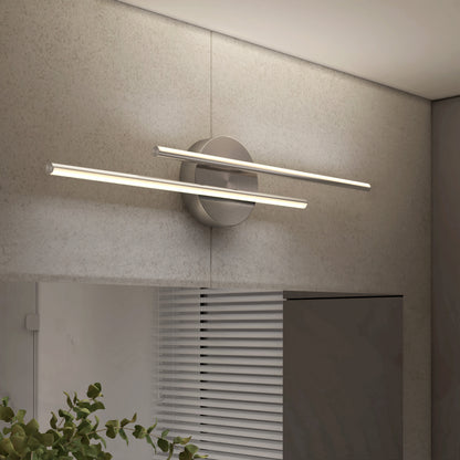 The Artika Cisco modern LED bathroom vanity light 5 CCT features two horizontal bars emitting soft white light with adjustable color balance, wall-mounted above a window with blinds and a leafy green plant nearby.