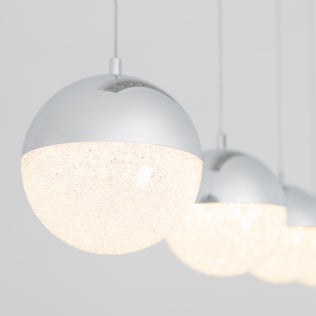 The Artika Sparkle 4-light LED pendant features four modern spherical lights with metallic tops and textured, glowing bottoms, hanging in a row against a plain light background for a bright, contemporary look.