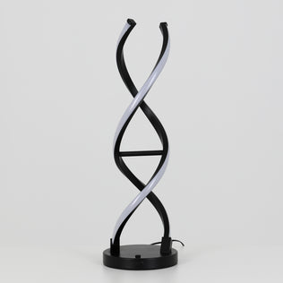 The Artika Swirl LED table lamp features a modern design with a black circular base and two intertwined, DNA helix-like light strips. This dimmable lamp is showcased against a plain white background.