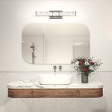 Modern bathroom with a marble countertop, wooden cabinet, rectangular sink, wall-mounted faucet, a vase of red and white flowers, large mirror, and contemporary light fixture above. White tiles in a herringbone pattern on the wall.