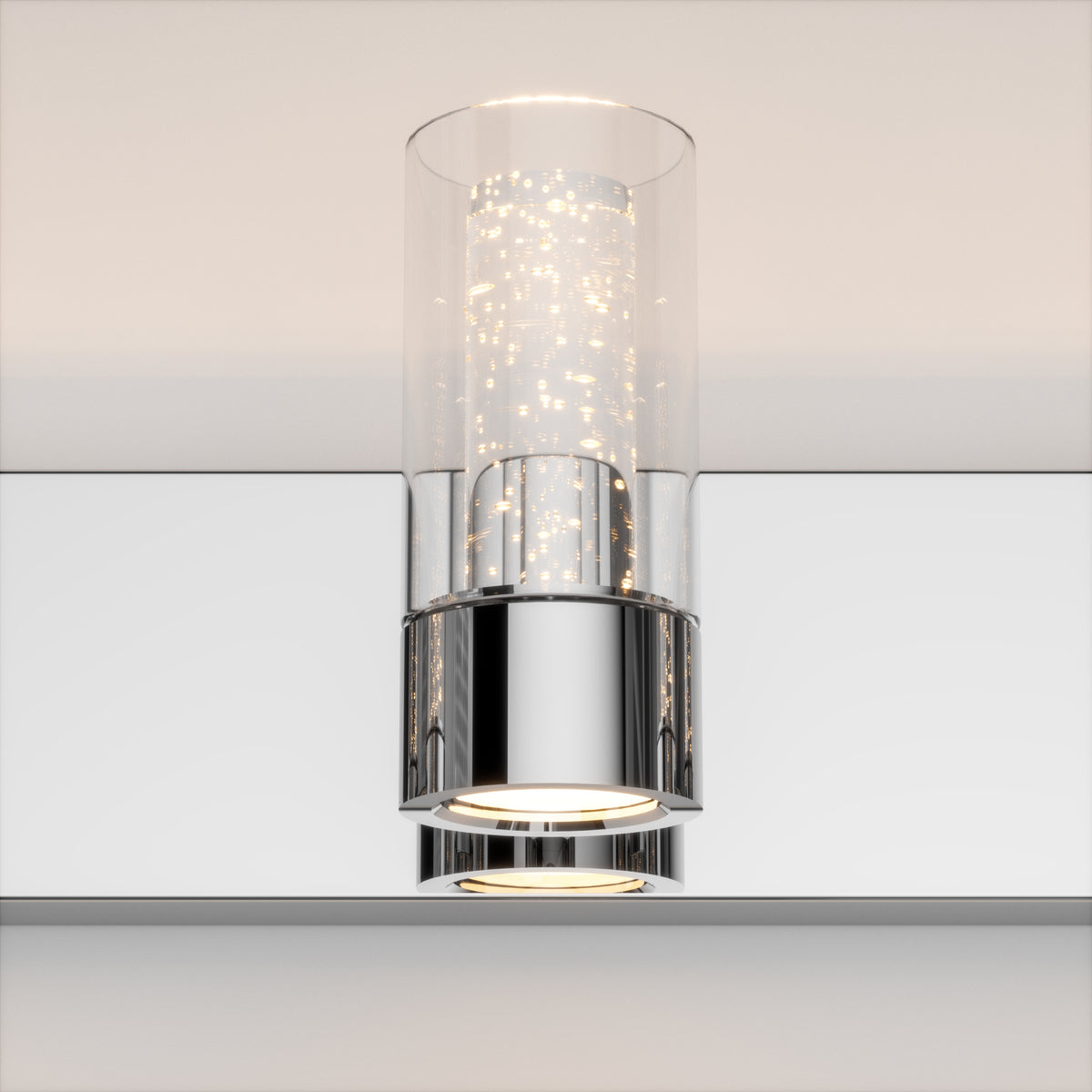 A modern wall-mounted light fixture with a cylindrical glass shade and chrome base, emitting warm white light with a sparkling effect inside the glass.