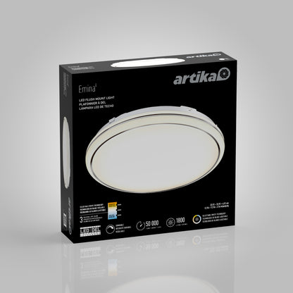 A black box with Artika branding displays the Emina LED flush mount light. The package features an image of the round light fixture and key specs: 50,000 hours, 1800 lumens, and energy efficiency icons.