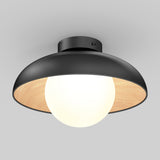 A modern ceiling light fixture with a black, dome-shaped shade and a light wood interior, featuring a large white globe bulb at the center, mounted on a white ceiling.